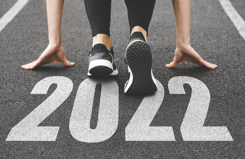 woman on starting blocks with 2022 painted on the ground